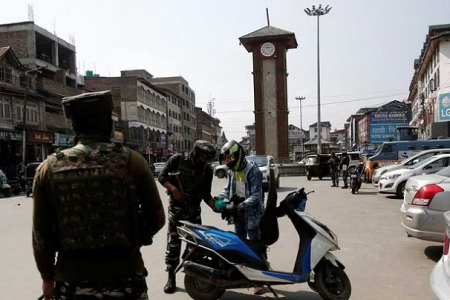 Indian Central Reserve Police Force (CRPF) personnel check the bags of a scooterist as part of security checking in Srinagar, October 12, 2021. REUTERS/Danish Ismail