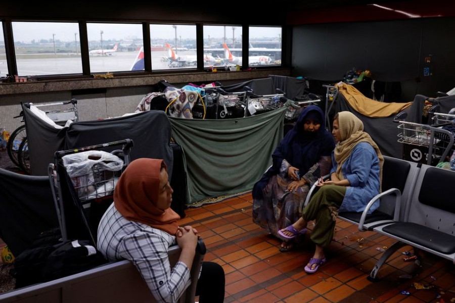 Afghan women talk near makeshift tents made out of blankets as they camp at Sao Paulo International airport in search of refuge in Guarulhos, Brazil, October 12, 2022. REUTERS/Amanda Perobelli