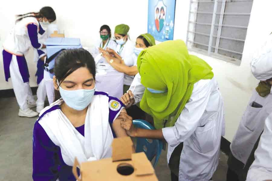 A health worker is inoculating a school girl against Covid-19 in Dhaka last year —FE File Photo