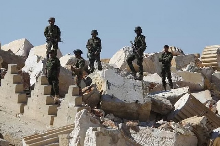 FILE PHOTO: Syrian army soldiers stands on the ruins of the Temple of Bel in the historic city of Palmyra, in Homs Governorate, Syria April 1, 2016. Reuters