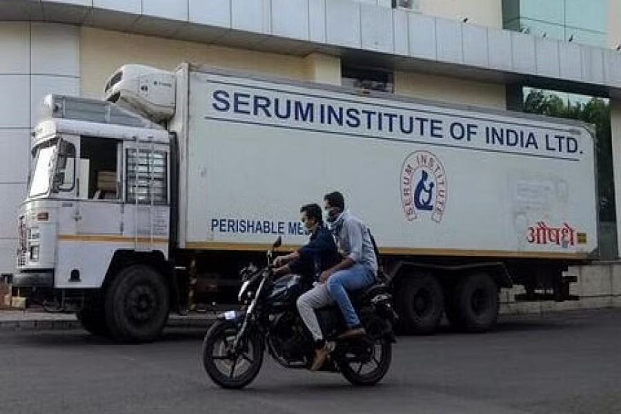 Men ride on a motorbike past a supply truck of India's Serum Institute, the world's largest maker of vaccines, Pune, India, May 18, 2020. REUTERS/Euan Rocha