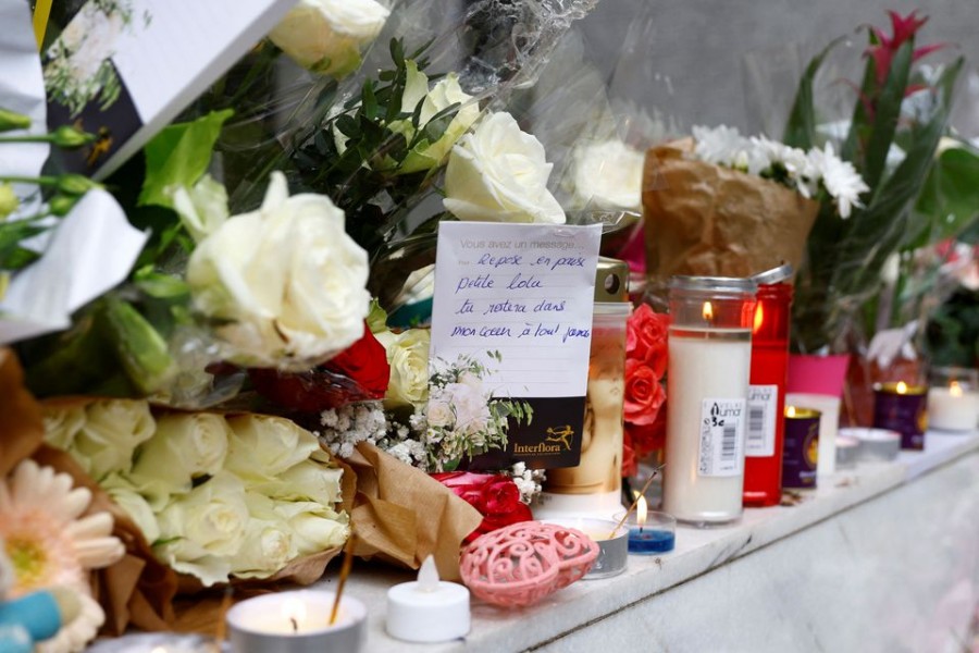 Flowers with a hand-written message which reads "Rest in peace little Lola, you will stay in my heart forever" are displayed outside the building where a 12-year-old schoolgirl Lola lived, who was brutally killed and whose body was stuffed in a trunk in the 19th district in Paris, France, October 18, 2022. REUTERS/Gonzalo Fuentes