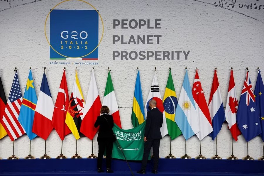 Employees arrange the Saudi Arabian flag during the final preparations before world leaders gather for the official family photograph on day one of the G20 leaders summit at the convention center of La Nuvola, in Rome, Oct 30, 2021. Ludovic Marin/Pool via REUTERS