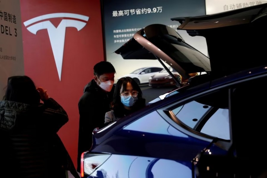 Visitors wearing face masks check a China-made Tesla Model Y sport utility vehicle (SUV) at the electric vehicle maker's showroom in Beijing, China on January 5, 2021 — Reuters/Files