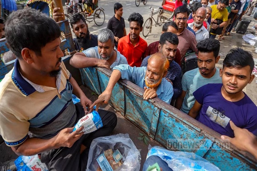 ঢাকার নিউ মার্কেট এলাকায় মঙ্গলবার টিসিবির ট্রাক থেকে ৫৫ টাকা কেজিতে চিনি কিনছেন এক ব্যক্তি।