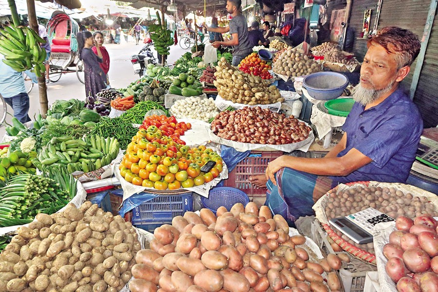 A vendor selling vegetables in his shop at a kitchen market in Motijheel area of the city on Friday. The prices of all types of vegetables witnessed a further hike this week, burning a hole in the consumers' pockets — FE photo