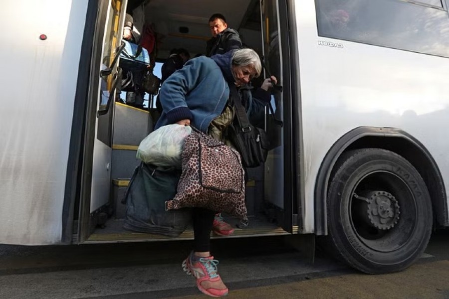 A woman gets off the bus as civilians evacuated from the Russian-controlled Kherson region of Ukraine arrive at a railway station in the town of Dzhankoi, Crimea, Oct 24, 2022. REUTERS