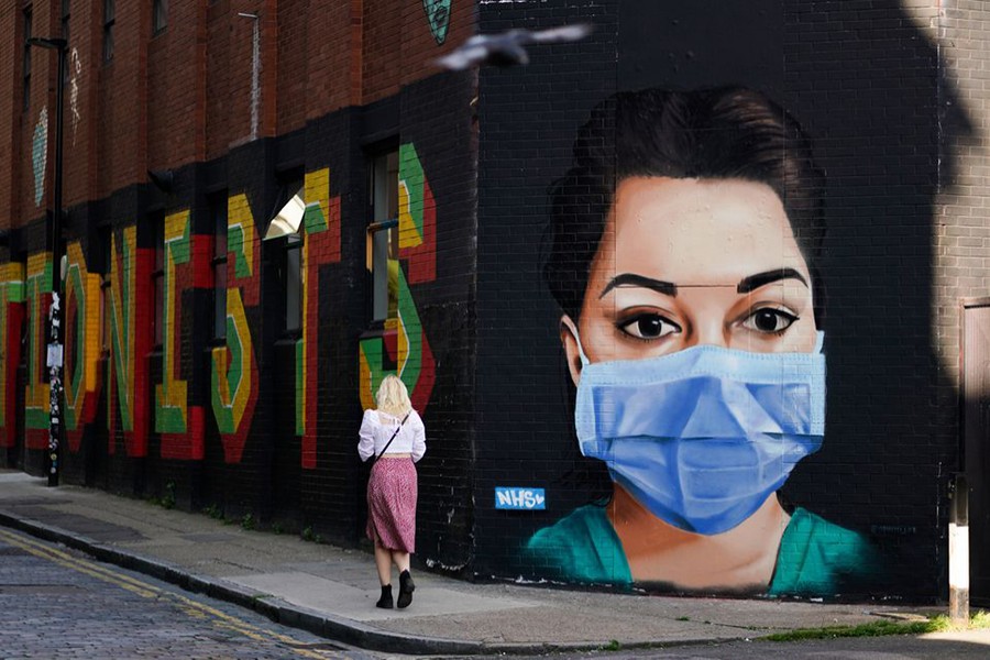 A woman walks past a mural depicting a nurse wearing a protective mask in Shoreditch, amid the coronavirus disease (Covid-19) outbreak, in London, Britain on April 21, 2020 — Reuters/Files