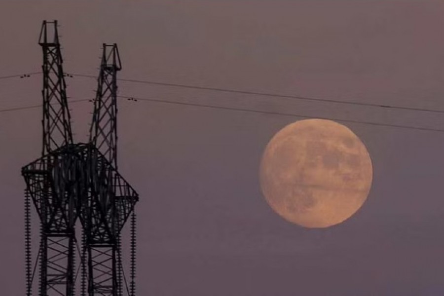 A full moon rises behind an electricity pylon with high-voltage power lines, amid Russia’s attack on Ukraine, in Dnipropetrovsk region, Ukraine November 7, 2022. REUTERS