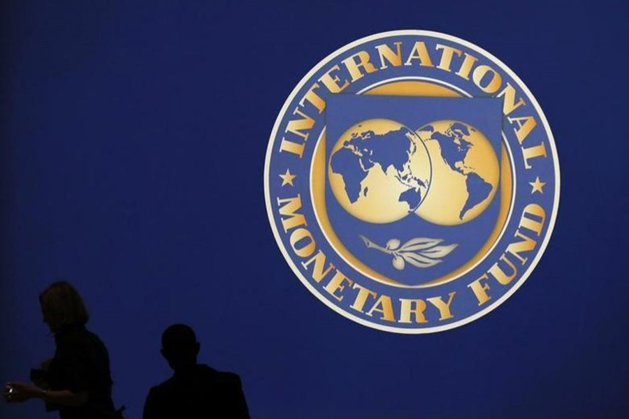 Visitors are silhouetted against the logo of the International Monetary Fund at the main venue for the IMF and World Bank annual meeting in Tokyo on October 10, 2012 — Reuters/Files