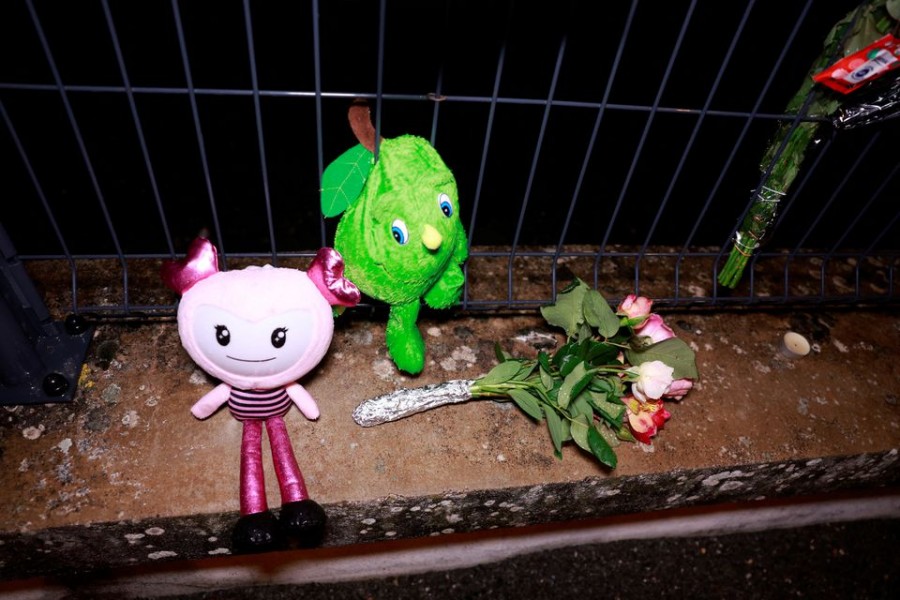 Flowers and toys are displayed in front of a school following the rape and murder of a 14-year-old girl in Tonneins, France, November 21, 2022. REUTERS/Vincent West