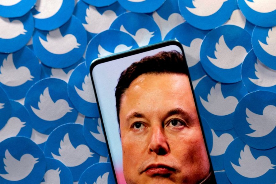 An image of Elon Musk is seen on a smartphone placed on printed Twitter logos in this picture illustration taken April 28, 2022. REUTERS/Dado Ruvic/Illustration/File Photo