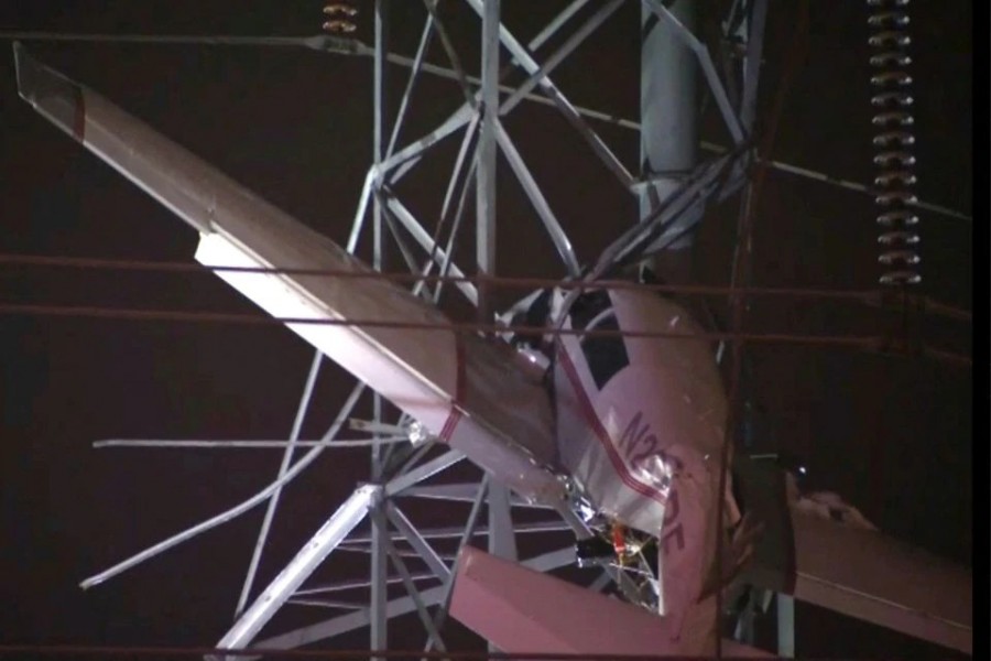 A small airplane hangs about 100 feet (33 metres) above the ground after crashing into an electricity tower in Gaithersburg, Maryland, U.S. November 27, 2022 in a still image from video — ABC affiliate WJLA via REUTERS