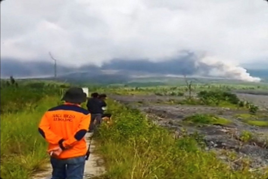 People look on as volcanic ash fills the sky during an eruption of the Semeru volcano in Lumajang, East Java Province, Indonesia December 4, 2022 in this screen grab obtained from a social media video. Instagram/@Gustiallah Foundation/via REUTERS