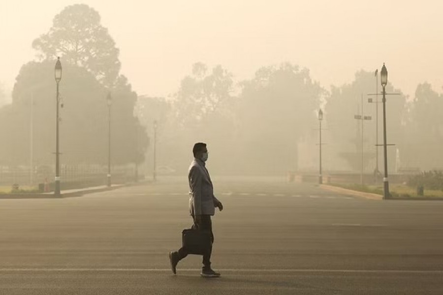 A man walks along a road on a smoggy morning in New Delhi, India, Dec 23, 2020. REUTERS Reuters