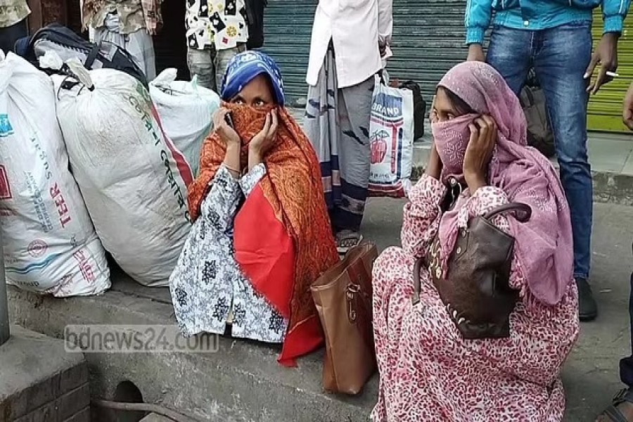 রাজশাহীতে ধর্মঘটের সময় গাড়ি না পেয়ে ফুটপাতে বসে দুই নারী। এমন চিত্র বিএনপির প্রায় প্রিতিটি বিভাগীয় সমাবেশের আগে দেখা গেছে।ফাইল ছবি