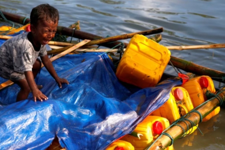 FILE PHOTO: A Rohingya refugee boy cries as he arrives on a makeshift raft after crossing the Bangladesh-Myanmar border, at Sabrang in Teknaf, near Cox's Bazar, Bangladesh. Nov 11, 2017. Reuters