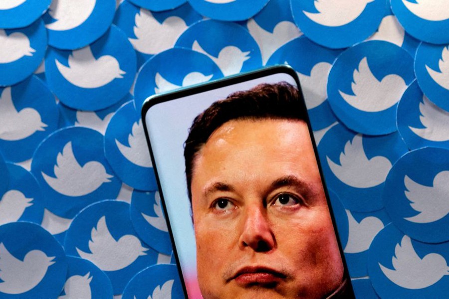 An image of Elon Musk is seen on a smartphone placed on printed Twitter logos in this picture illustration taken on April 28, 2022 — Reuters/Files