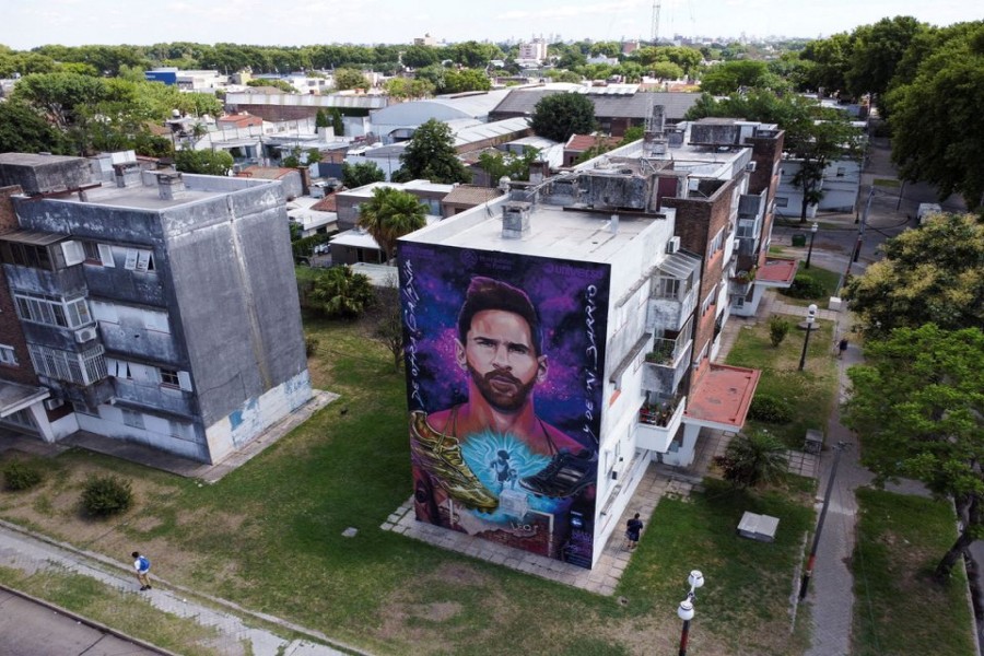Pedestrians walk past a mural depicting Argentine soccer star Lionel Messi near the home where he was born, in Rosario, Argentina December 15, 2022. REUTERS/Agustin Marcarian TPX IMAGES OF THE DAY