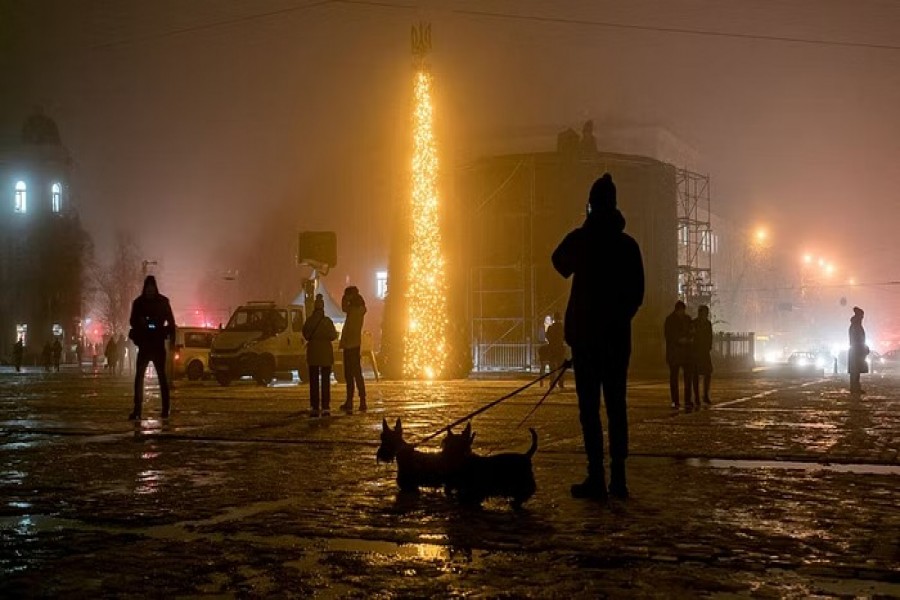 People walk past a Christmas tree during heavy fog at the Sofiyska square, amid Russia's invasion of Ukraine, in Kyiv, Ukraine December 17, 2022. Reuters