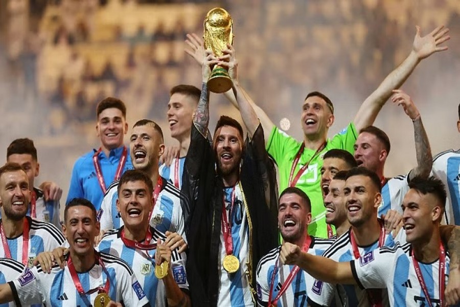 Football - FIFA World Cup Qatar 2022 - Final - Argentina v France - Lusail Stadium, Lusail, Qatar - Dec 18, 2022 Argentina's Lionel Messi lifts the World Cup trophy alongside teammates as they celebrate winning the World Cup REUTERS