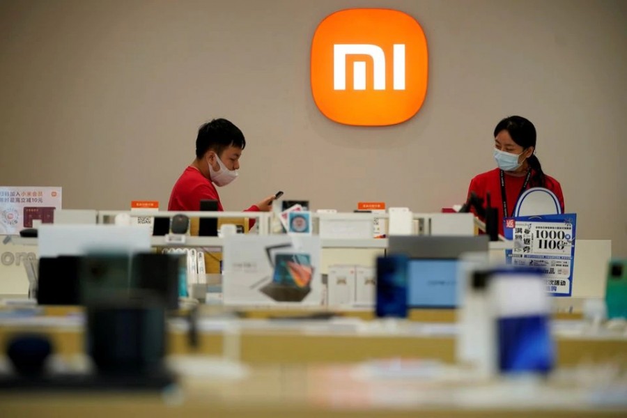 Staff members stand near the company logo at a Xiaomi store in Shanghai, China on November 1, 2021 — Reuters/Files