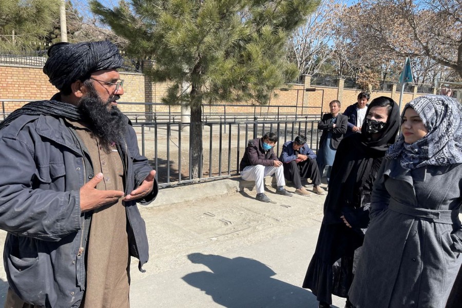 A member of Taliban speaks with female students outside the Kabul Education University in Kabul, Afghanistan, February 26, 2022. REUTERS/Stringer/File Photo