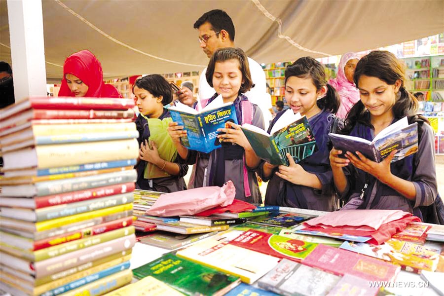 Children browse books at a stall in the Amar Ekushey Boi Mela in Dhaka —Xinhua Photo