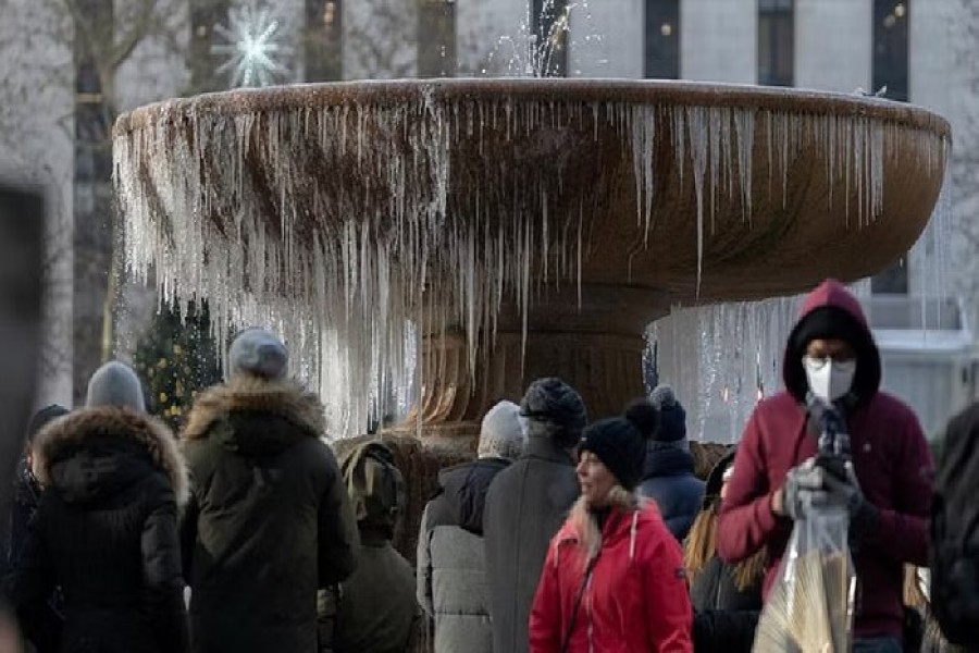 People stand in front of a mostly frozen Bryant Park fountain on Christmas Eve in Manhattan on Christmas Eve in Manhattan, New York City, US, Dec 24, 2022. REUTERS