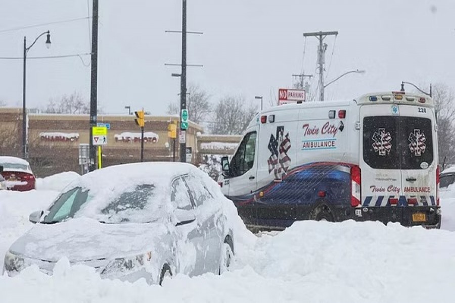 An ambulance passes an abandon car during a winter storm that hit the Buffalo region, in Amherst, New York, US, Dec 26, 2022. REUTERS.