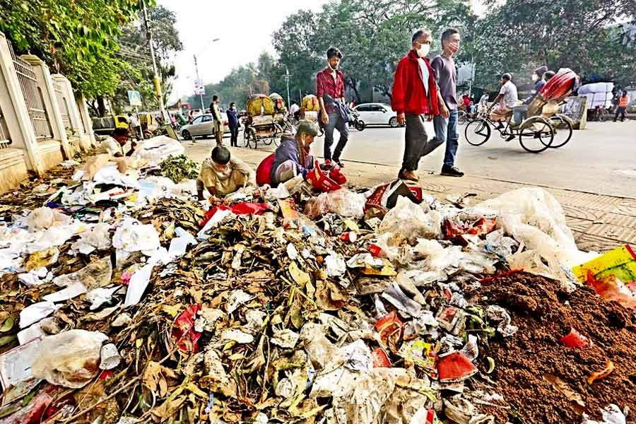 Pedestrians walking past a heap of garbage in the city’s Dhaka Medical College and Hospital area — FE file photo