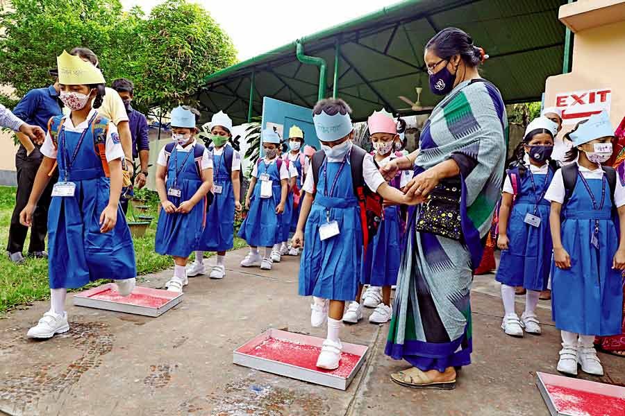 Students disinfecting their shoes on sanitizer-soaked mats as part of maintaining health guidelines while entering a school in Dhaka during a wave of Covid-19 pandemic —FE file photo