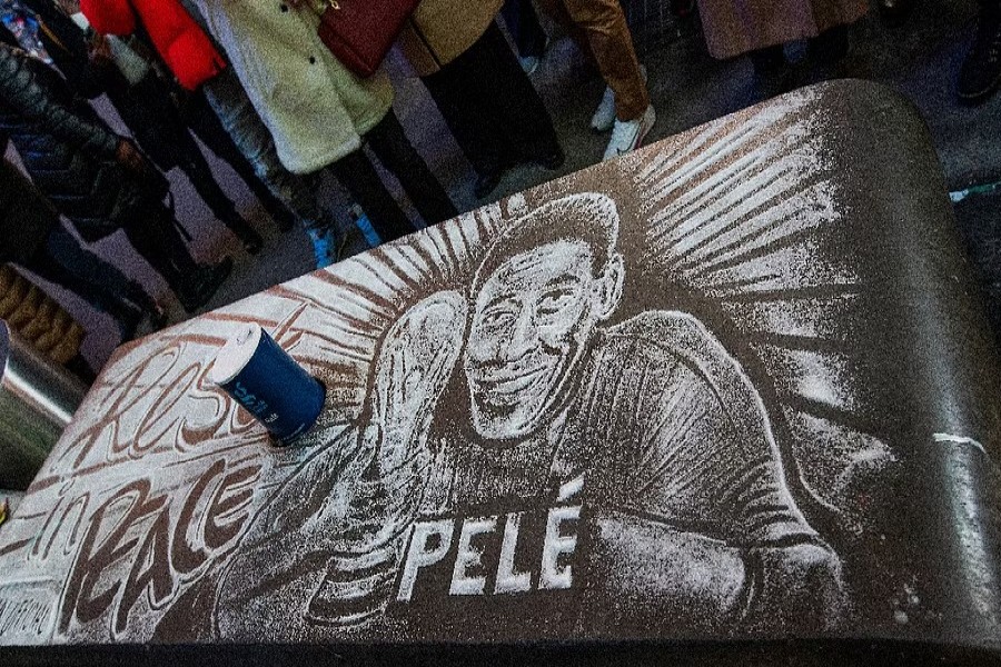 An image of Brazilian soccer legend Pele drawn with salt as a memorial is seen while people mourn his death at the Pele soccer store in Times Square in the Manhattan borough of New York City, US, Dec 29, 2022. REUTERS
