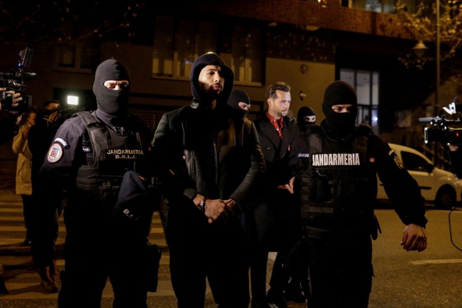 Andrew Tate and Tristan Tate are escorted by police officers outside the headquarters of the Directorate for Investigating Organized Crime and Terrorism in Bucharest (DIICOT) after being detained for 24 hours, in Bucharest, Romania on December 29, 2022 — Inquam Photos via REUTERS