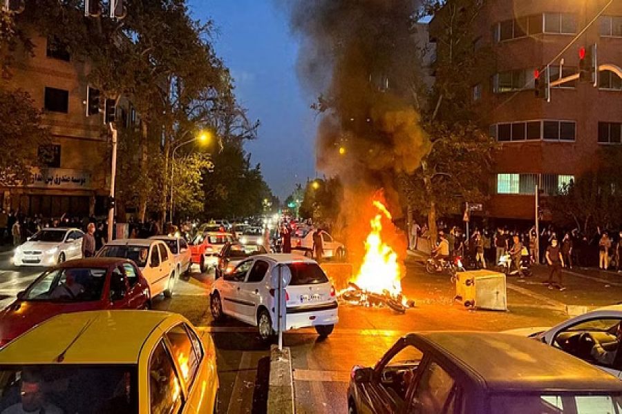 A police motorcycle burns during a protest over the death of Mahsa Amini, a woman who died after being arrested by the Islamic republic's "morality police", in Tehran, Iran Sept 19, 2022. WANA (West Asia News Agency) via REUTERS