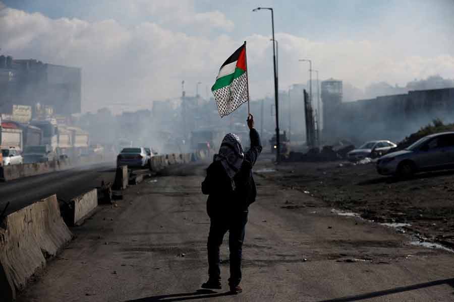 A man walking with a Palestinian flag near Qalandia in the Israeli-occupied West Bank on December 27 last year -Reuters file photo