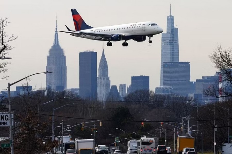 A Delta Airlines jet comes in for a landing in front of the Empire State Building and Manhattan skyline after flights earlier were grounded during an FAA system outage at Laguardia Airport, in New York City, New York, US, January 11, 2023. REUTERS