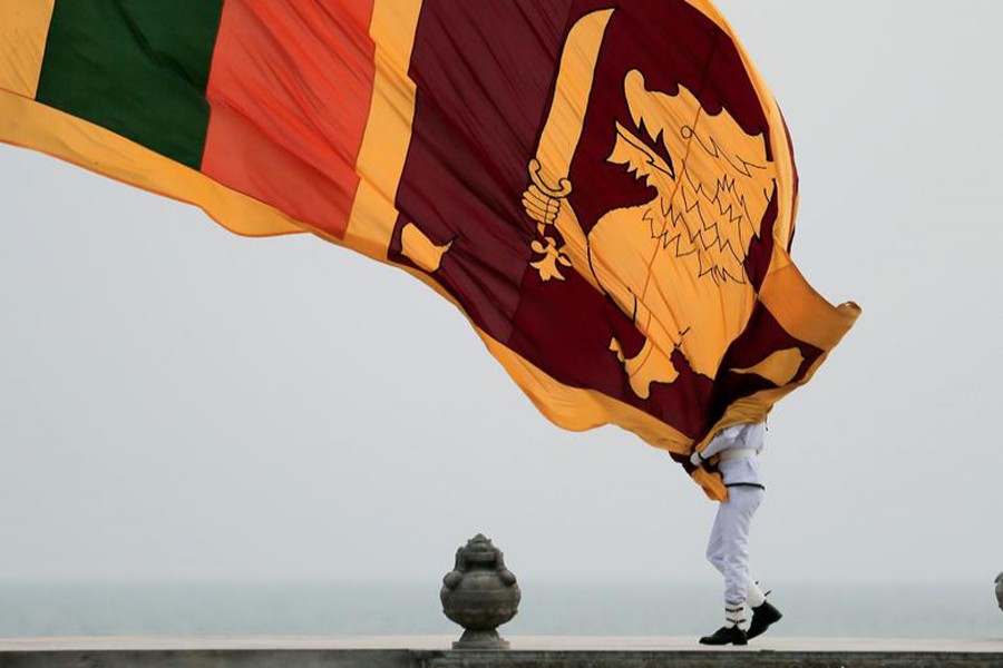 Sri Lankan military officer lowers the national flag at the flag square in Colombo, Sri Lanka on March 23, 2021 — Reuters/Files