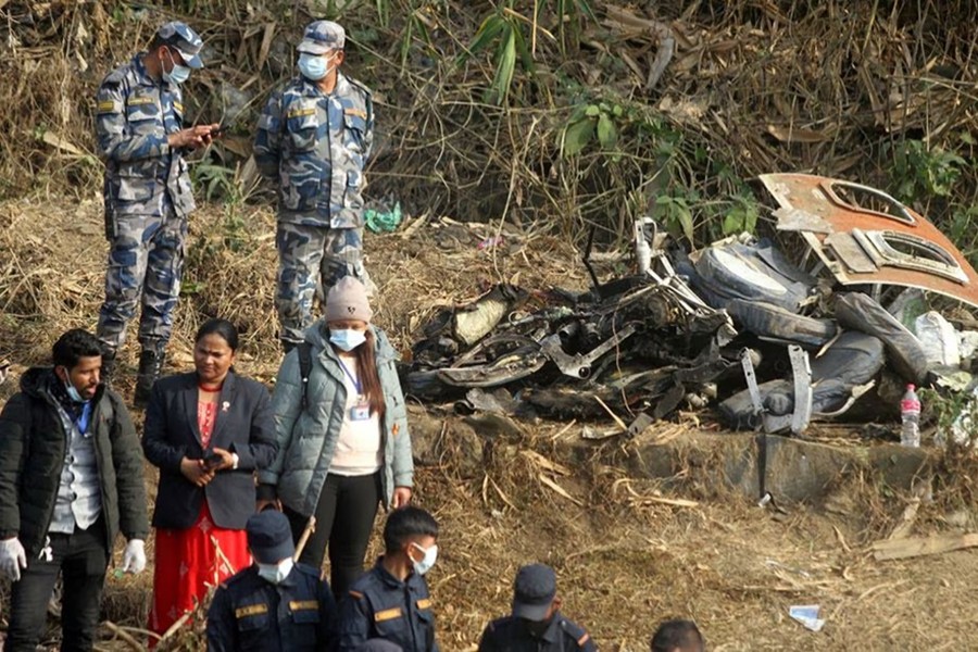 People stand near the wreckage at the crash site of an aircraft carrying 72 people in Pokhara in western Nepal on January 15, 2023 — reuters photo