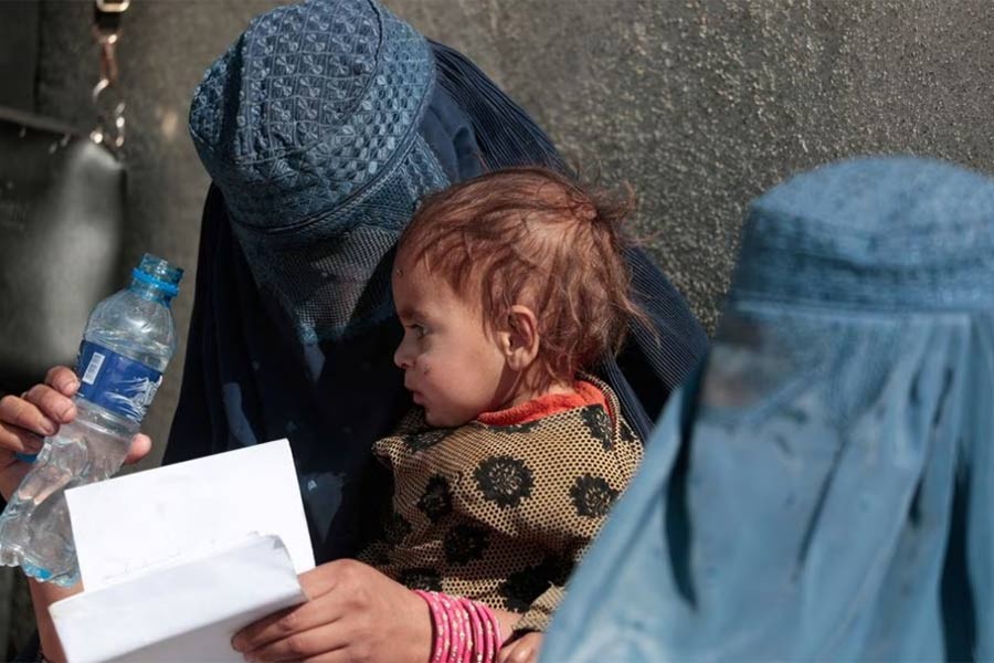 A displaced Afghan woman holding her child at an UNCHR centre of aid distribution on the outskirts of Kabul in 2021 –Reuters file photo