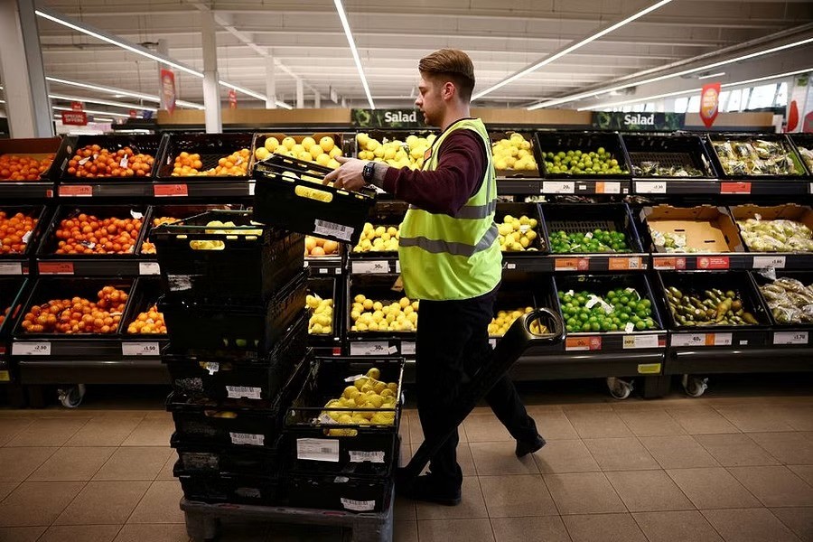 An employee arranges produce inside a Sainsbury?s supermarket in Richmond, west London, Britain, June 27, 2022. REUTERS