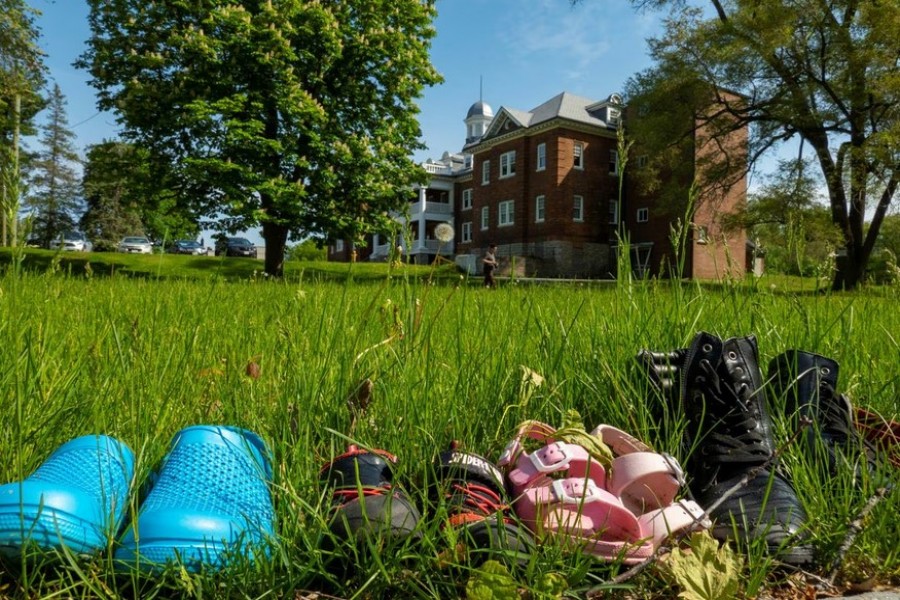 Children's shoes are pictured outside the Mohawk Institute, a residential school for indigenous children that operated for 136 years, during the planting of commemorative apple trees on the former grounds which is now the Mohawk Village Memorial Park in Brantford, Ontario, Canada May 24, 2022. REUTERS/Carlos Osorio/File Photo