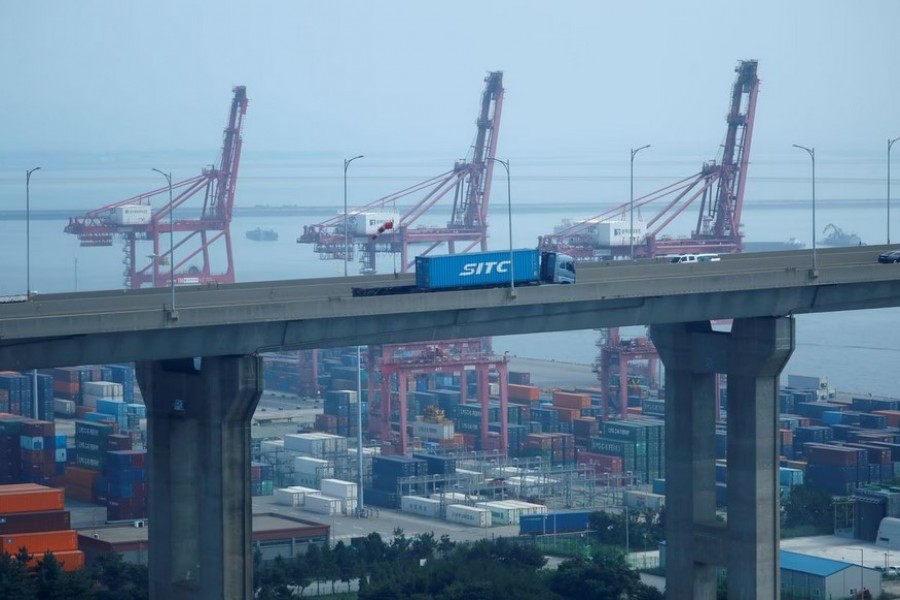 A truck carrying a shipping container travels past cranes at Pyeongtaek port in Pyeongtaek, South Korea, July 9, 2020. REUTERS/Kim Hong-Ji/File Photo