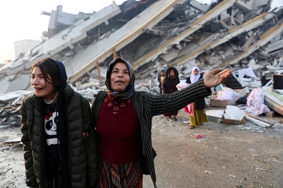 Women react near rubble following an earthquake in Hatay, Turkey, Feb 7, 2023. REUTERS/Umit Bektas