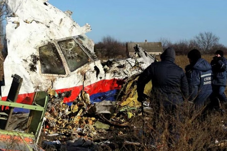 Local workers transport a piece of wreckage from Malaysia Airlines flight MH17 at the site of the plane crash near the village of Hrabove (Grabovo) in Donetsk region, eastern Ukraine November 20, 2014. REUTERS/Antonio Bronic