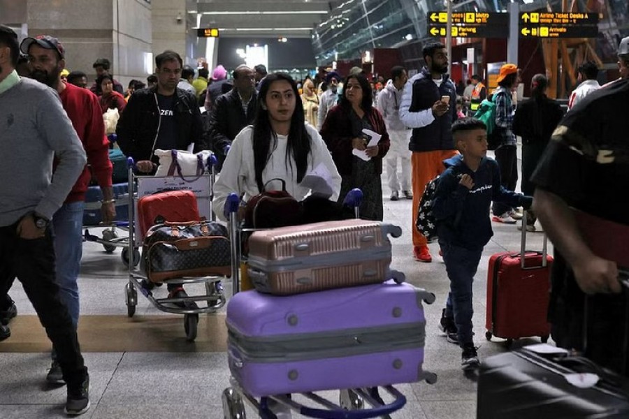 Travellers push carts with their luggage at the departure area of Terminal 3 at Indira Gandhi International Airport in New Delhi, India, Dec 14, 2022. REUTERS