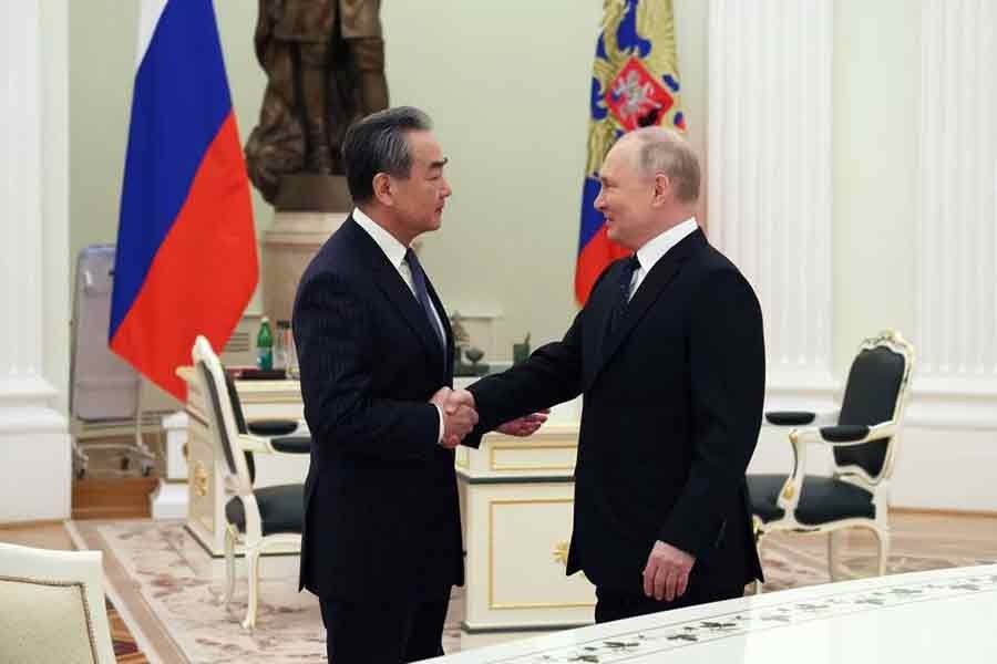 Russia's President Vladimir Putin shaking hands with China's Director of the Office of the Central Foreign Affairs Commission Wang Yi during a meeting in Moscow on Wednesday –Reuters photo